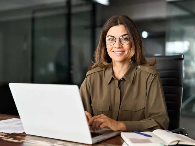 Profissional de jaleco à mesa do consultório